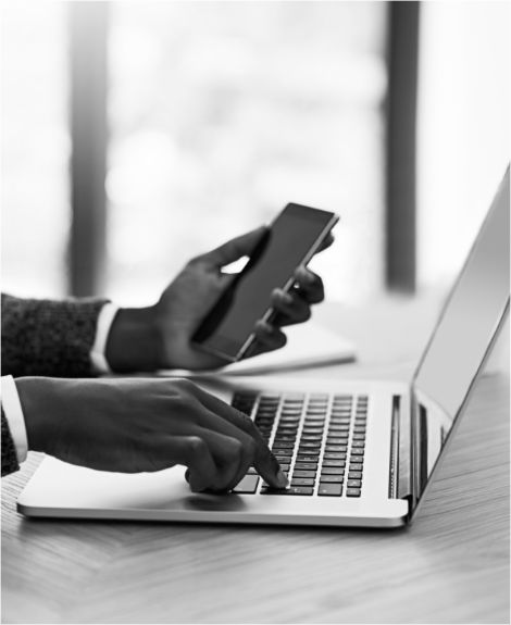 Person working on their laptop holding a cell phone with Integrity Failures stats